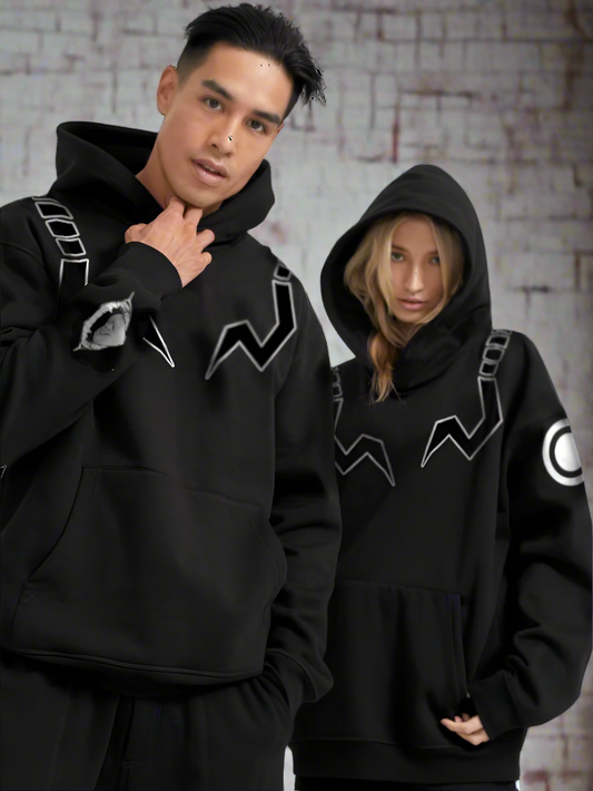 Two people wearing black hoodies with unique designs on a white background